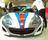 гоночная модификация Mazda MX-5 Open Race, участвующая в одноименных соревнованиях, выпущенная в честь юбилея самого популярного в мире родстера Mazda MX-5, которому в 2010 году исполнилось 20 лет<BR>